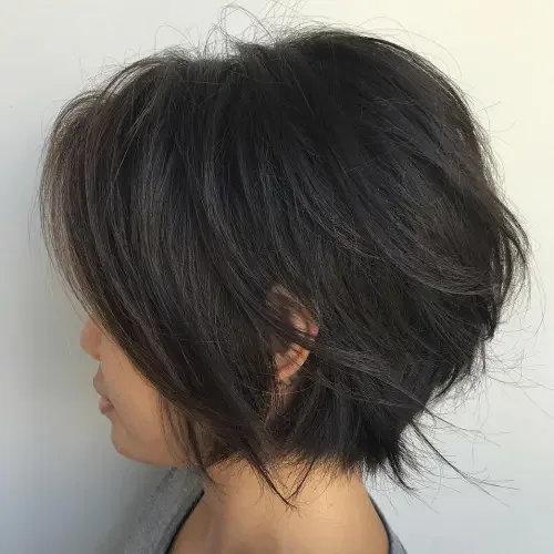 Feathered chin-length bob with jagged layers and soft fringe effect.