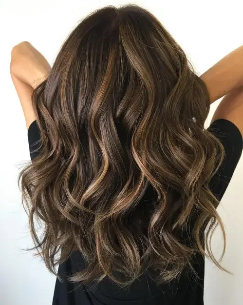 Long chocolate brown hair with bouncy curls and balayage highlights