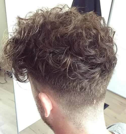 Curly top with a short undercut taper and dark brown ringlets