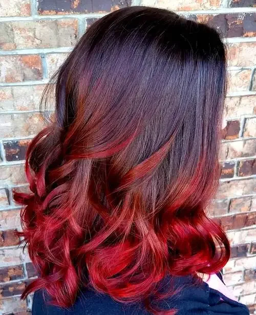 Near-black bob with vivid red ombre streaks in defined curls.