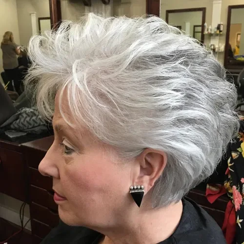 White-silver short shag with deep side part and layered, tousled volume.