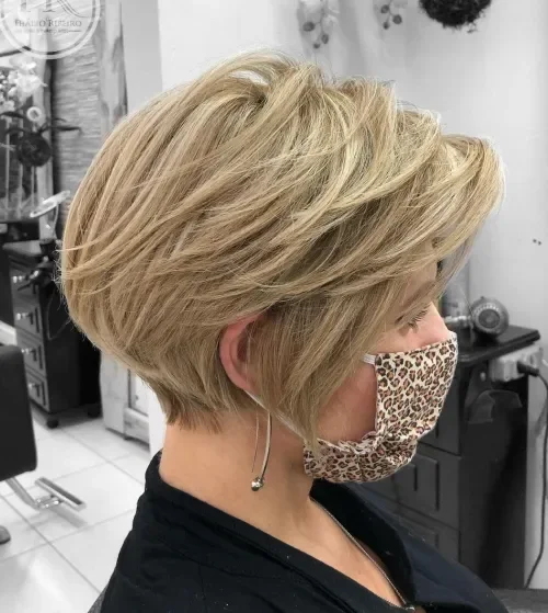 Beige blonde pixie bob with swoopy layers and arched fringe