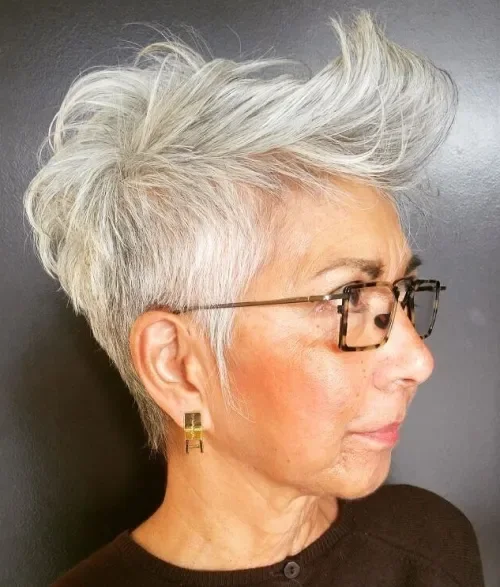 Flipped-up bang pixie cut in cool gray with airy texture and back-swept volume.