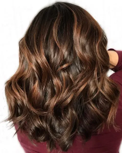 Long wavy dark brown hair with caramel-cinnamon ribbon highlights
