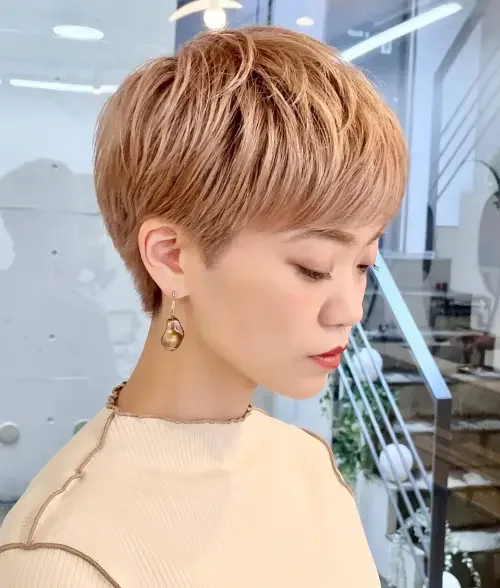 Warm copper layered pixie with short fringe and tapered sides, rounded top volume.