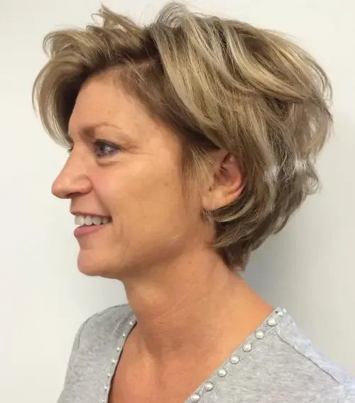 Tousled ash blonde bixie with side-swept layers and a soft fringe around the ears.