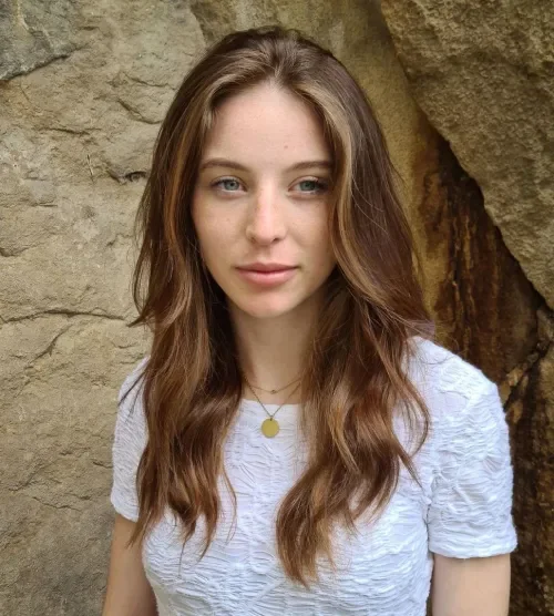 Long loose waves lob with a center part and warm brown caramel highlights.