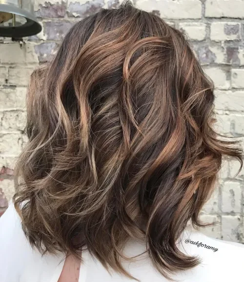 Shoulder-length balayage waves with face-framing layers and caramel highlights.