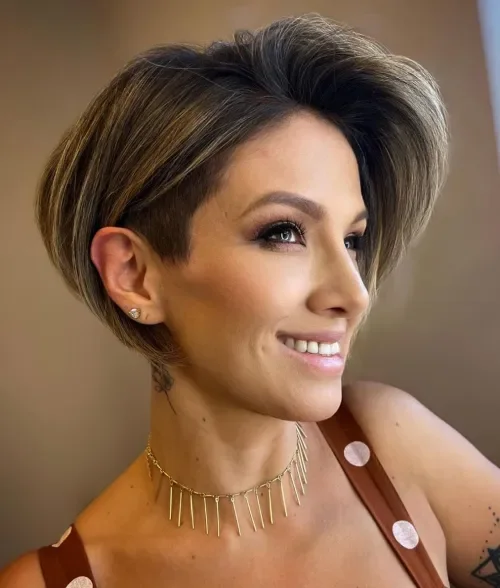 Feathered pixie-bob with tapered sides and warm highlights on a rounded, layered crown